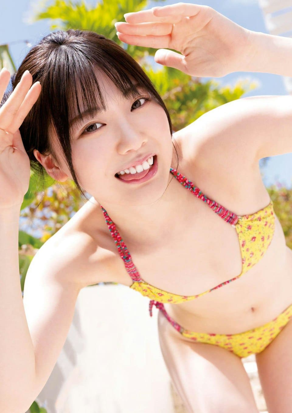 日本女優石川澪穿著黃色碎花泳裝拍攝戶外寫真，面向鏡頭露出活潑自然的笑容